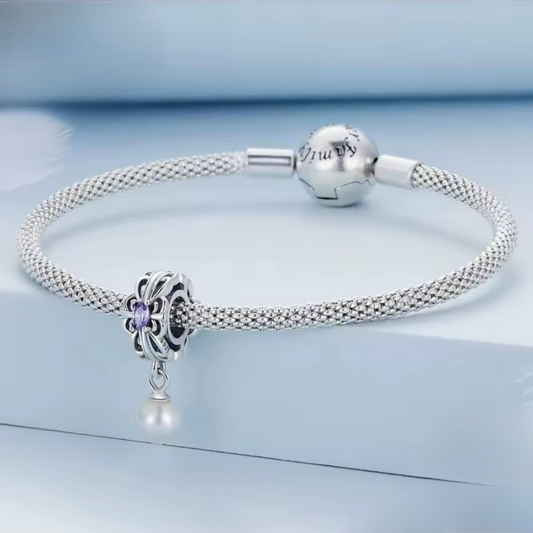 Hermoso charm colgante con perla y circonia central morada